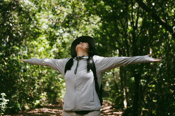Young female traveler with backpack walking in national park or forest. recreation sport in nature....