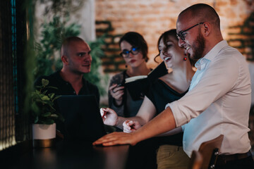 Business team collaborating indoors on a startup project. They are engaged in discussion and...
