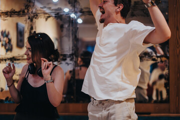 A happy group of friends enjoying a fun and energetic dance at a lively indoor gathering, expressing excitement and joy in a festive atmosphere.