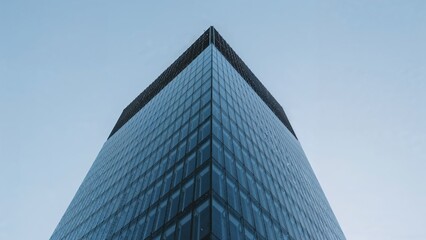 Modern glass skyscraper against a pale sky.
