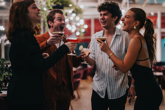 A group of friends shares joy and laughter during a night out, enjoying cocktails in a stylish bar. The atmosphere is lively and filled with happiness.