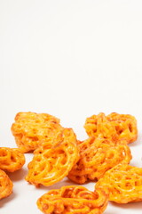 A pile of spicy Indonesian crackers or Kerupuk with spiral twists, coated in red-orange chili powder and rich spices. Bold, flavorful, and appetite-boosting. Photographed against a white background.