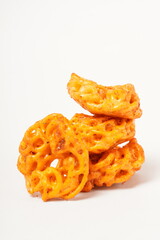 A pile of spicy Indonesian crackers or Kerupuk with spiral twists, coated in red-orange chili powder and rich spices. Bold, flavorful, and appetite-boosting. Photographed against a white background.