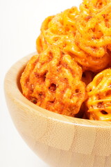 A pile of spicy Indonesian crackers or Kerupuk with spiral twists, coated in red-orange chili powder and rich spices. Bold, flavorful, and appetite-boosting. Photographed against a white background.