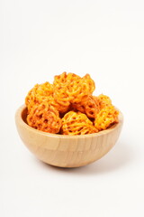 A pile of spicy Indonesian crackers or Kerupuk with spiral twists, coated in red-orange chili powder and rich spices. Bold, flavorful, and appetite-boosting. Photographed against a white background.