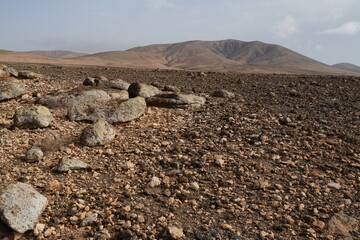volcanic arid landscapes with trils, cliffs, and scattedred vegetation.