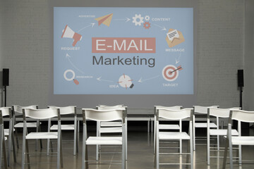 Empty chairs in front of projection screen with E-mail marketing scheme in conference room