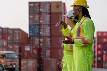 Industrial engineer standing at shipping container yard inspecting cargo delivering loading as...