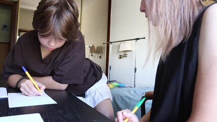 Young student writing with teacher's assistance