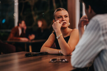 A young couple enjoying a deep conversation at a dimly lit restaurant, capturing moments of...