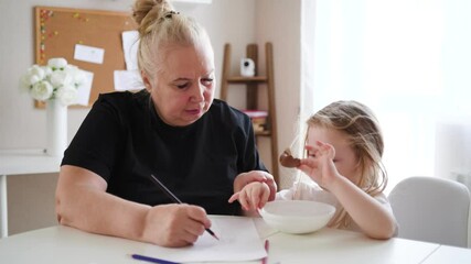 Grandmother spending quality time with her granddaughter, playing, laughing, and drawing together. Warm family moments full of joy, creativity, and bonding - Powered by Adobe