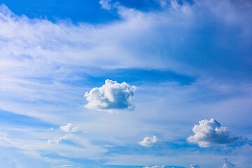 The evening sky is filled with thick and thin clouds against a backdrop of pale blue and lavender....
