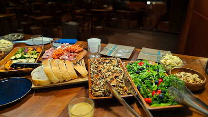 Enjoying a family homemade dinner buffet — roasted chicken thigh  mushrooms truffle sauce, kale salad blueberries cherry tomatoes, pan-fried zucchini sweet potatoes, marinated meat, prosciutto bread