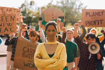 Young black woman leading climate change protest with diverse group