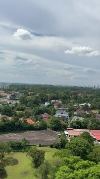 aerial view of luch greenery and houses. buildings in the distance