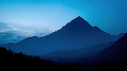 Obraz premium Mountain silhouette under twilight sky, serene blue tones blending into dusk, nature's quiet grandeur
