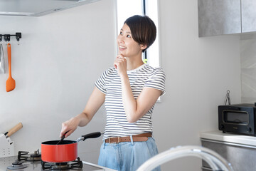 キッチンで料理をしている笑顔の女性