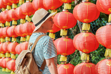 Female tourist enjoying view of traditional Chinese red lanterns