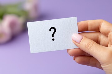 Person Holding Blank White Business Card with Question Mark on Purple Background