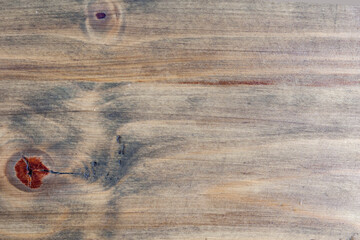 The wood grain is rough and uneven, with a few knots and splinters