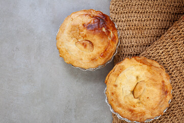 Two pies on a table with a brown cloth