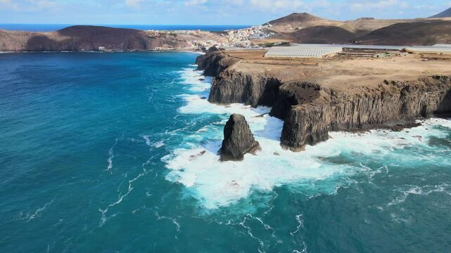 Turquoise ocean waves crashing against the rocky cliffs of Risco Partido, Gran Canaria, Spain