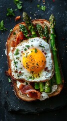 Delicious breakfast with eggs, bacon and asparagus on a dark background, useful for cooking blogs and healthy eating articles.