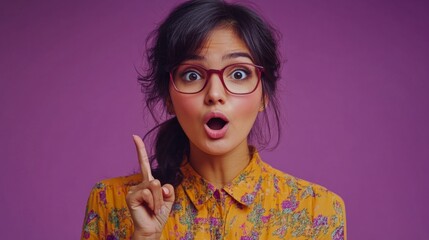 Woman wearing glasses with raised finger on purple background, useful for advertising and educational materials.