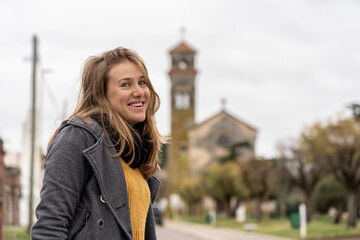 Woman standing on quiet street with historic church behind