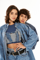 Young couple showcases stylish denim looks, expressing love and fashion in a modern setting