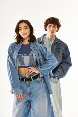 Stylish young couple embraces love and fashion in denim at a modern studio
