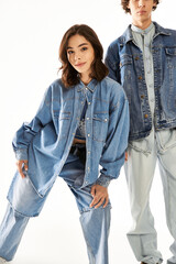 Stylish young couple expressing love through modern denim fashion in bright studio setting