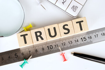 The concept word TRUST is assembled from wooden cubes. Investment based on trust concept