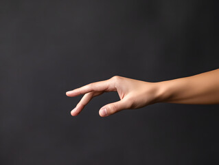 Human hand reaching out with fingers slightly bent against dark background, symbolizing connection, hesitation, or gentle touch in minimalistic style