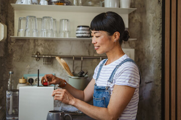 Japanese woman housewife use a capsule coffee machine prepare coffee