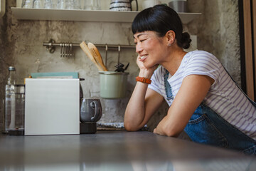 Japanese woman wait for coffee to be prepared in a kitchen at home