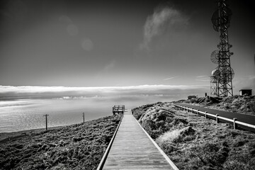 Black and white coastal landscape with a boardwalk leading to the ocean.