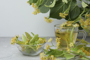 cup of herbal tea with linden flowers on wooden background