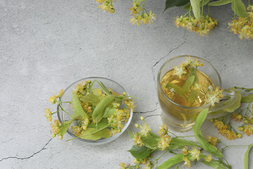 cup of herbal tea with linden flowers on wooden background