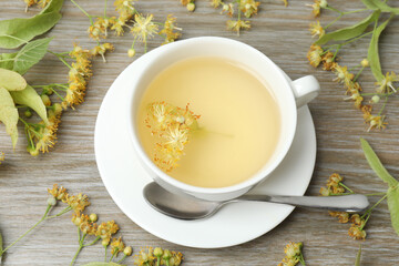 cup of herbal tea with linden flowers on wooden background