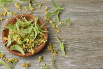 cup of herbal tea with linden flowers on wooden background