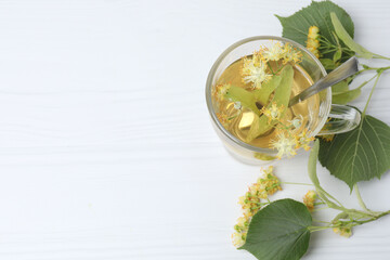 cup of herbal tea with linden flowers on wooden background