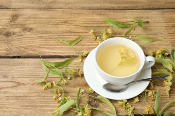 cup of herbal tea with linden flowers on wooden background