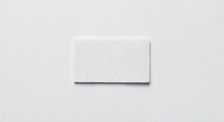 Care label patch isolated on white background, blank fabric tag, photorealistic top-down view