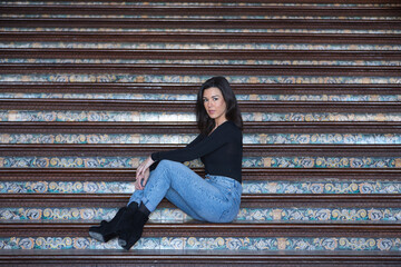 Young, pretty, brunette woman in black long sleeved t-shirt and jeans, relaxed and calm, posing...