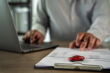 Insurance on paperwork assurance person is working desk with laptop, pointing document with small...