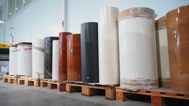 Large rolls of decorative vinyl foil in warehouse offer variety of designs. Decorative vinyl foil for use in lamination in interior projects