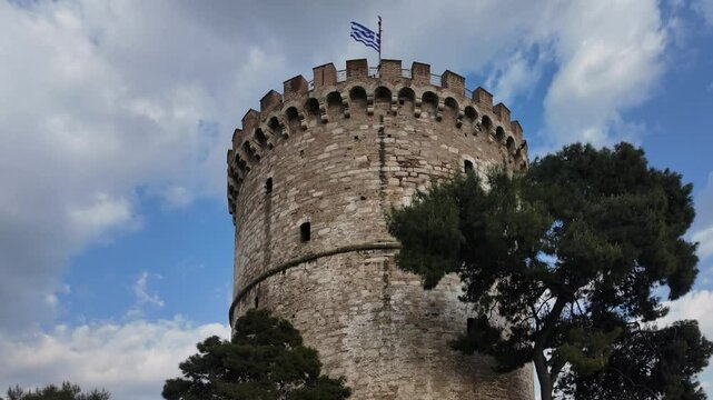 Griechenland - der wei&szlig;e Turm von Thessaloniki aus der Froschperspektive mit V&ouml;geln, die oben starten in Zeitlupe