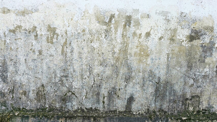 A close-up view of an aged, distressed wall reveals intricate textures of peeling paint, revealing a story of time, decay, and the beauty of imperfection. Ancient cracked, damp and moldy stucco wall.