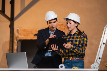 Engineering people and contractor wearing safety helmet on construction site holding blueprint in...